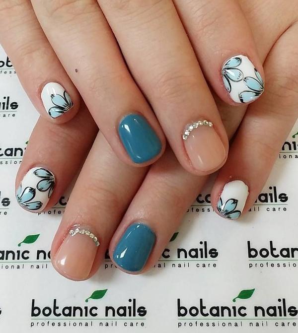 A really pretty nude nail art design with matte green blue polish. You can also see beautiful flower details painted on top of the white polish as well as silver beads aligned at the cuticles of the nude polished nails.