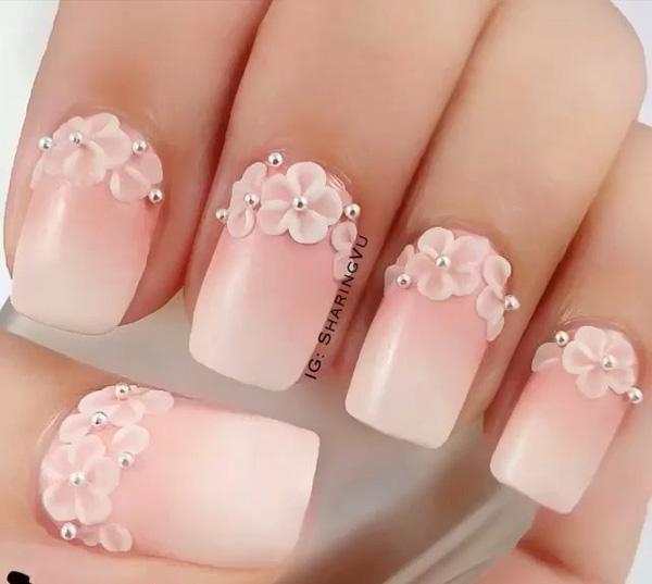 A wonderful looking gradient technique using nude and white nail polish. To make the nails stand out even tinier flower embellishments are placed on the cuticle edge of the nails complete with silver beads on top.