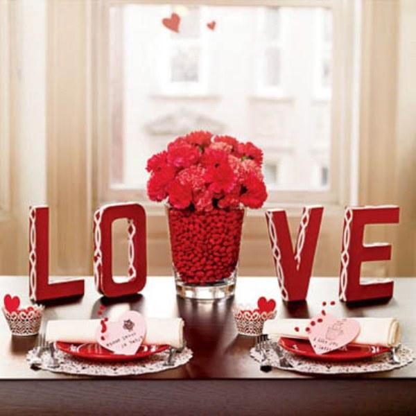 Exerting a bit of effort on the dinner table other than cooking your family or partner’s favorite meal can be much better. Have a stunning centerpiece with these red pebbles and red flower, a L-O-V-E design and messages on a heart cutout.