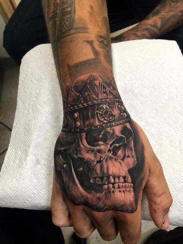 Skull with crown tattoo on hand for men