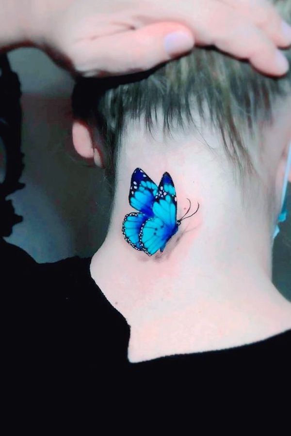 A realistic tattoo depicting a butterfly landing on the neck