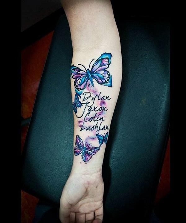 Two names tattooed on the forearm in butterflies in watercolor style