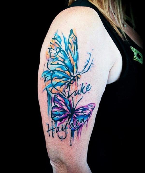 A tattoo of two names and two butterflies in watercolor style