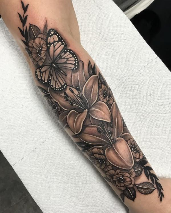 Black and grey lilies and butterfly forearm tattoo