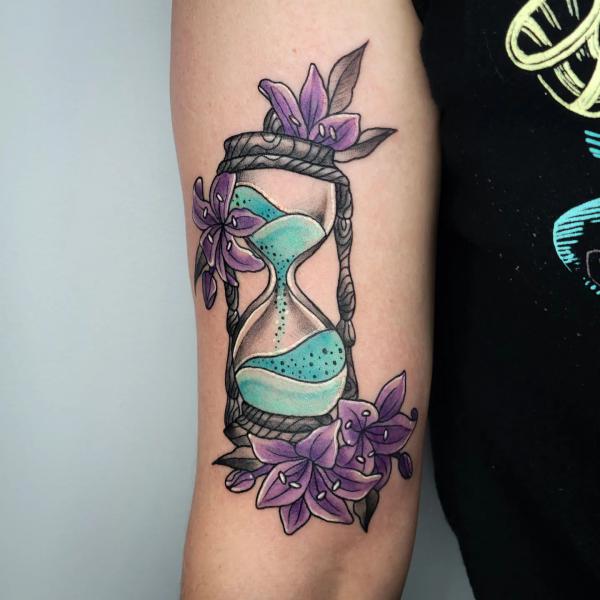 Hourglass adorned with purple lily flowers
