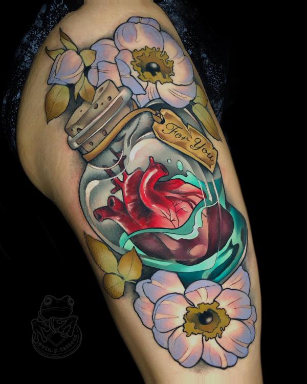 A human heart in bottle surrounded with flowers