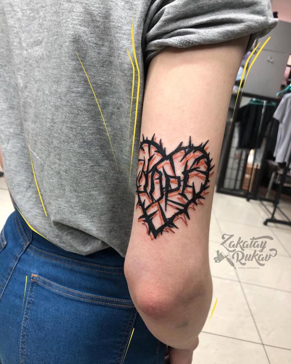Barbed wire heart above elbow tattoo