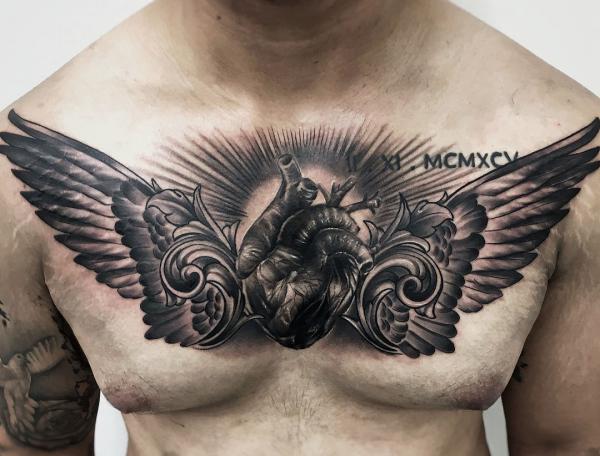 Blackwork heart with wings chest tattoo