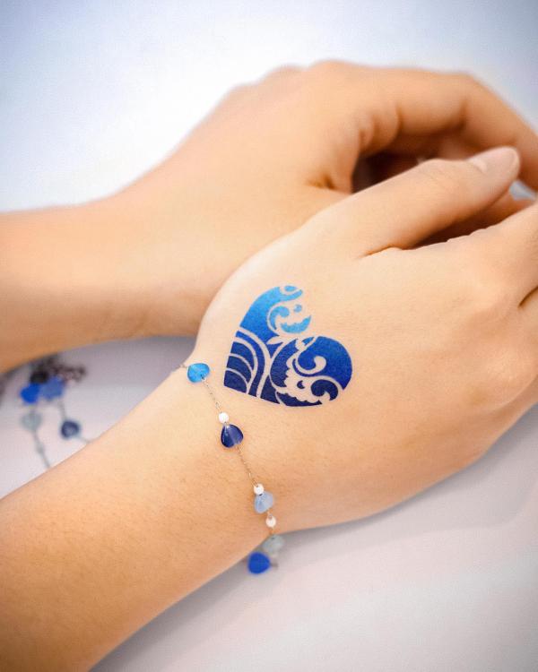Blue heart hand tattoo