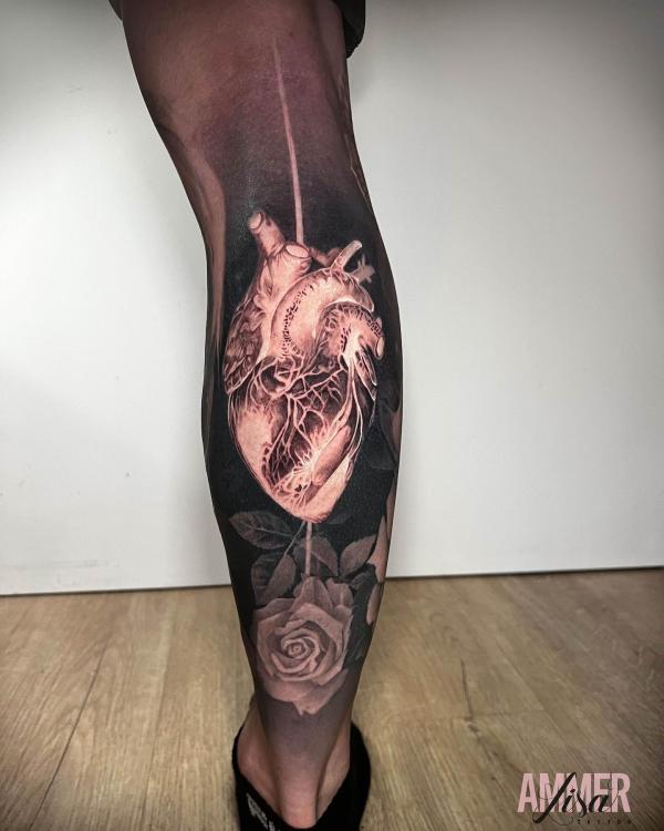 Human heart and dark rose calf tattoo