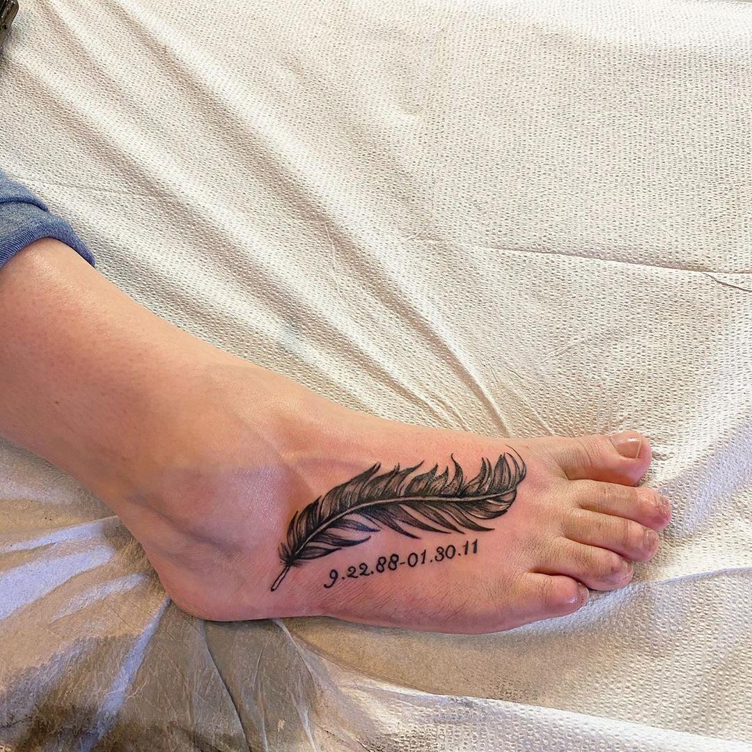 Black ribbon foot tattoo