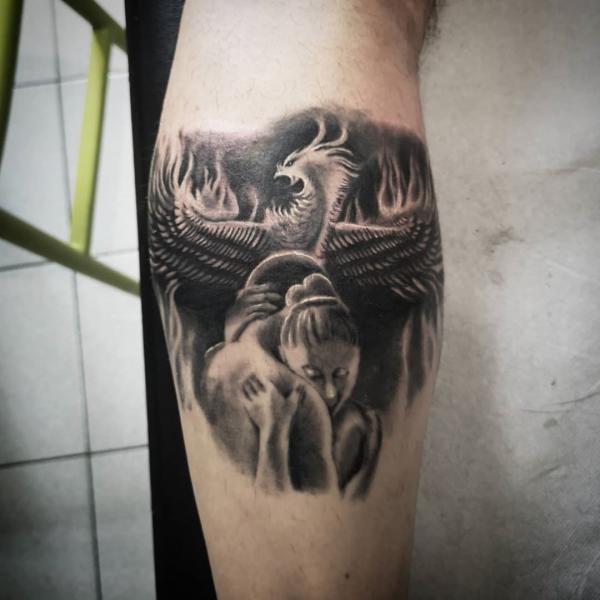 Black and white tattoo with phoenix and lovers on calf