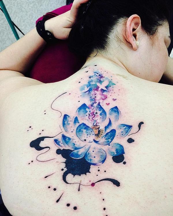 Birds, stars and love emerging from the bud of a lotus flower watercolor tattoo