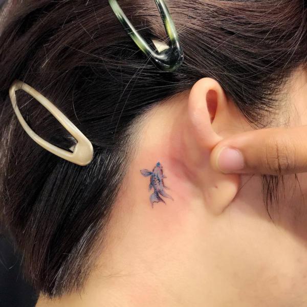 Minimalist fish tattoo behind ear
