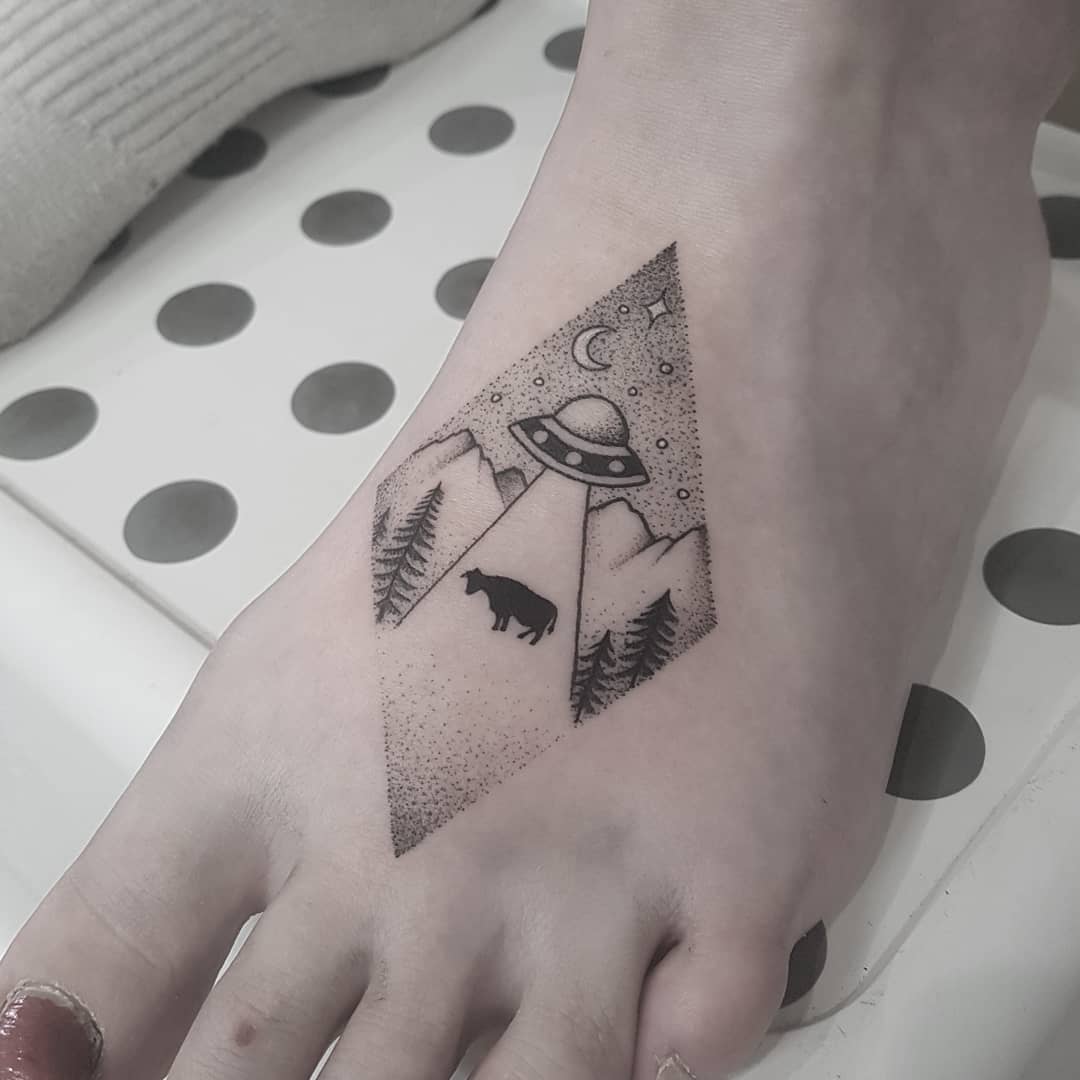 Black and white ankle tattoo with tiny lighthouse and forest