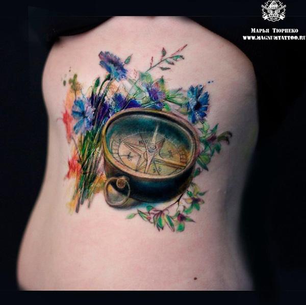 Vintage compass among colorful leaves and flowers