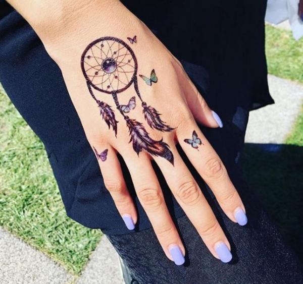 Dream catcher and butterfly tattoo on hand