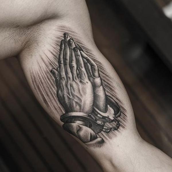 Praying hands with handcuffs tattoo