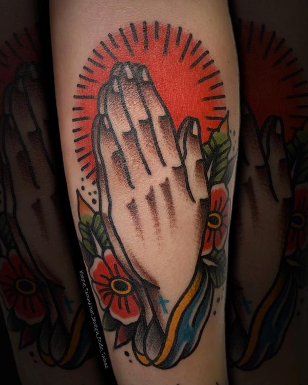 Traditional praying hands with flowers tattoo