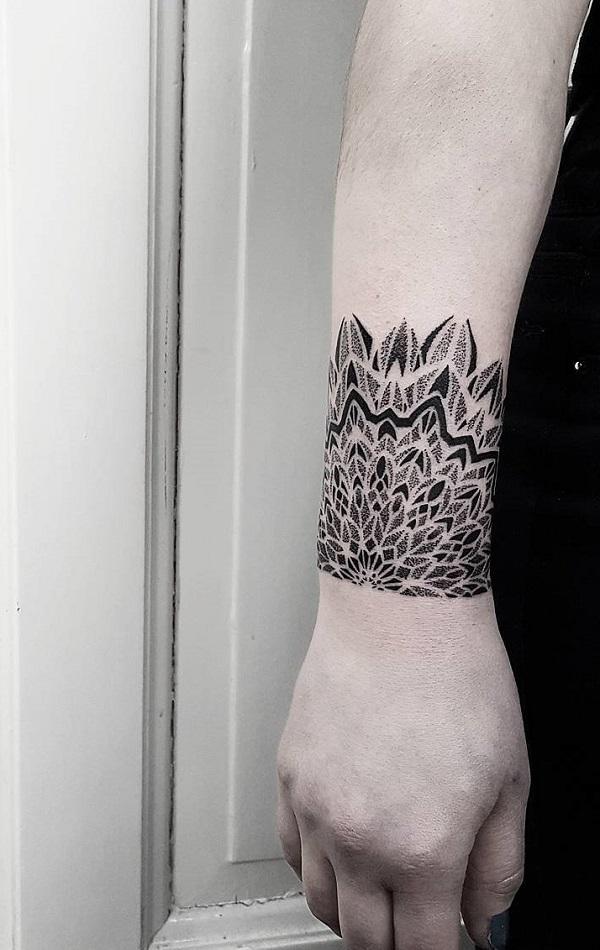 Forearm tattoo of a mandala.