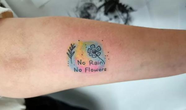 No rain no flowers arm tattoo