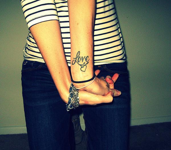 Word Love with a heart symbol wrist tattoo