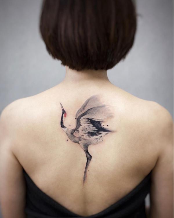 Black and white watercolor crane tattoo on back