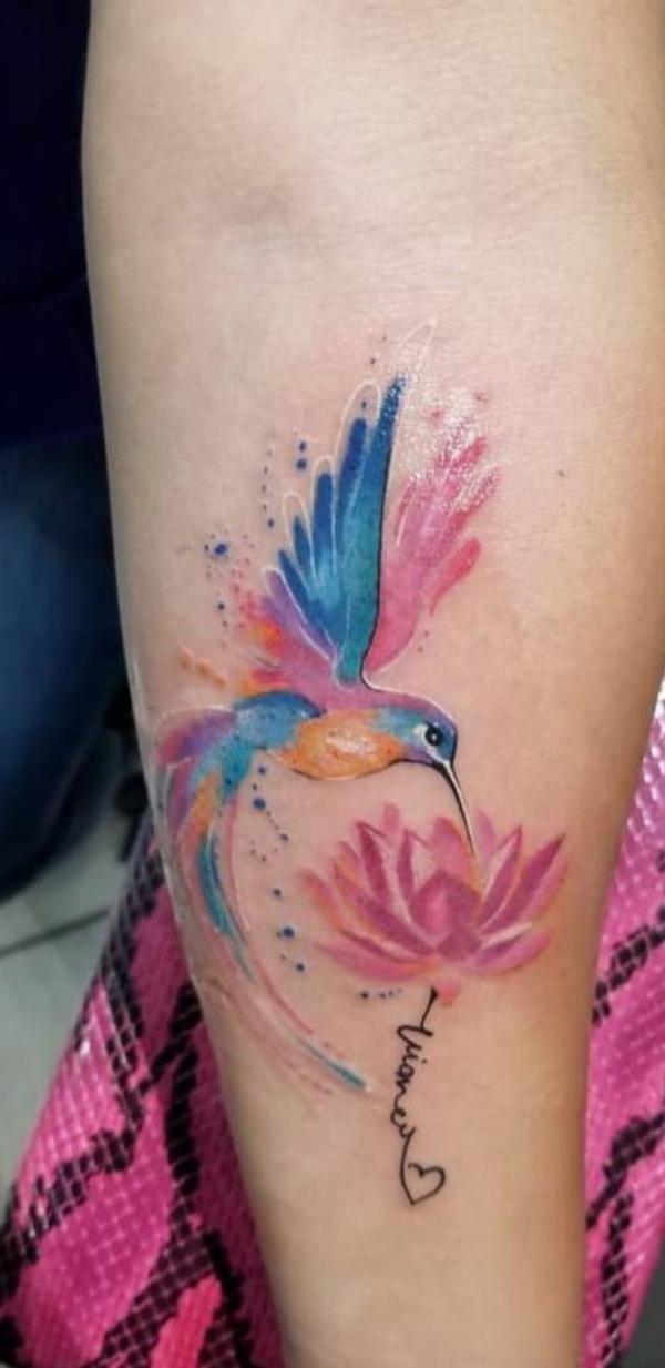 Watercolor hummingbird and lotus tattoo on forearm