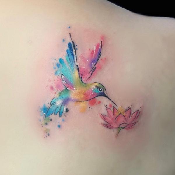 Watercolor hummingbird and lotus tattoo on shoulder blade