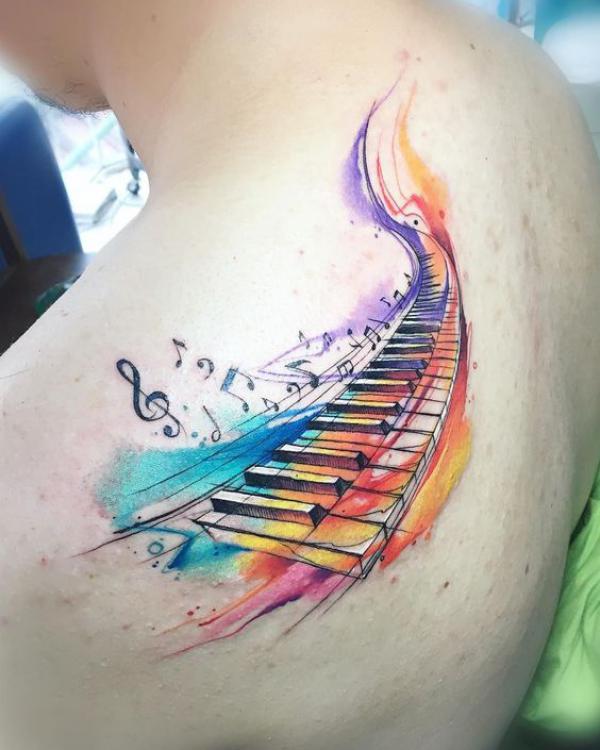 Watercolor piano keys and music notes tattoo