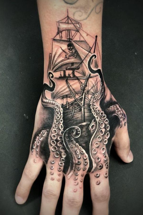 Black and grey octopus ship tattoo on hand