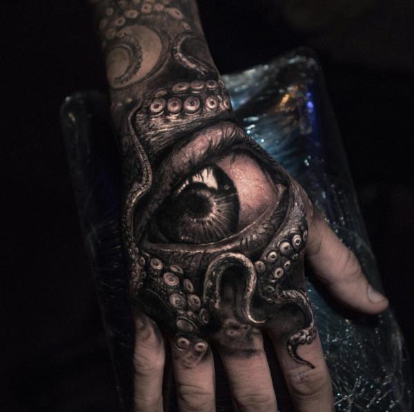Blackwork octopus with eye tattoo on hand