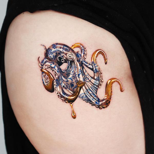 Golden octopus tattoo on thigh
