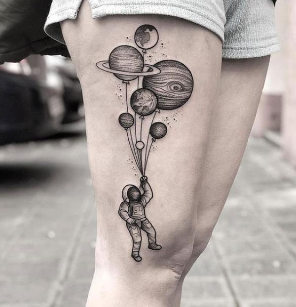 Astronaut solar system tattoo on the side of thigh