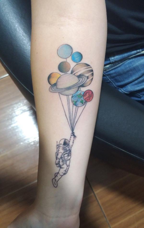 Colored astronaut solar system tattoo