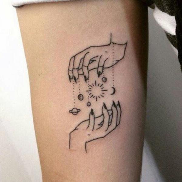 Hands holding solar system tattoo