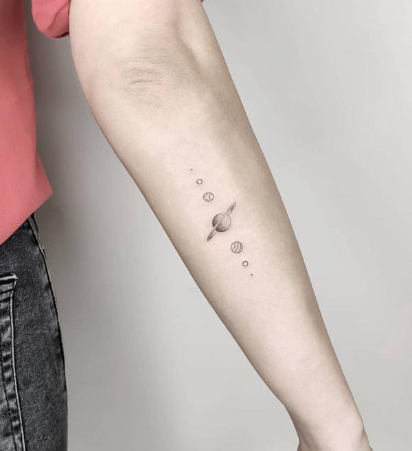 Minimalist solar system forearm tattoo