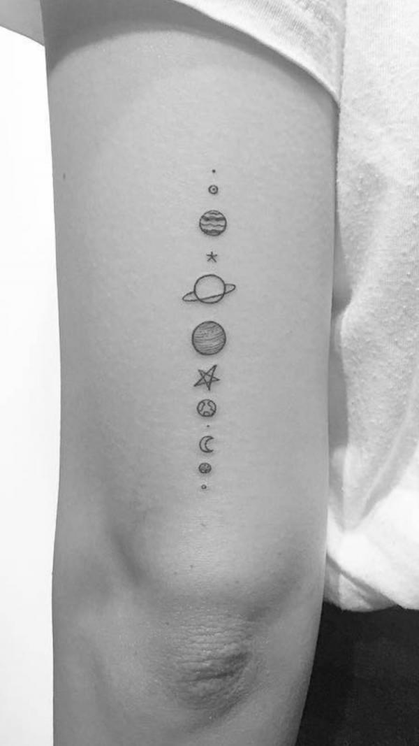 Minimalist solar system tattoo above elbow