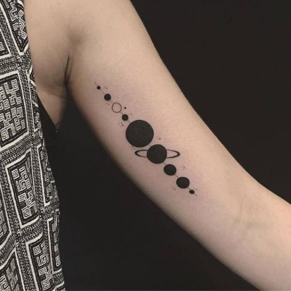 Silhouette solar system tattoo on bicep