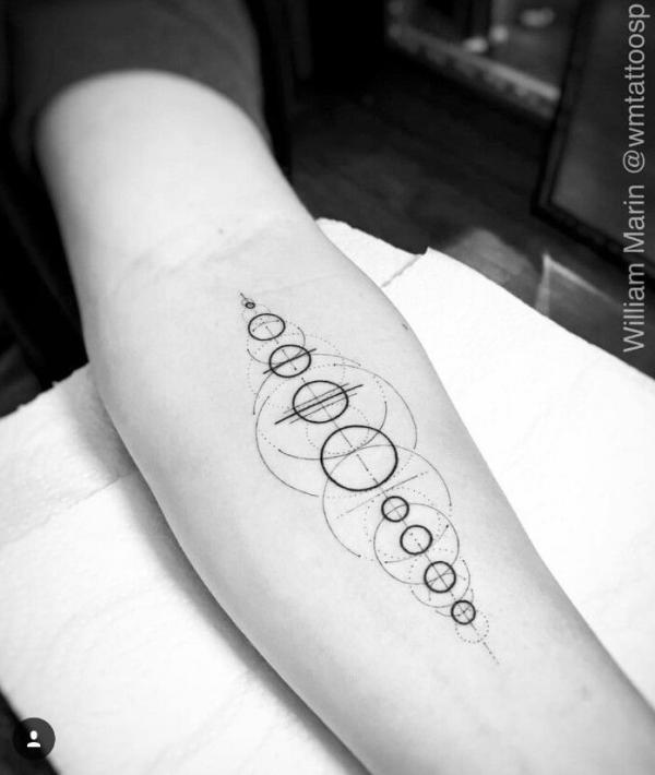 Solar system outline tattoo on forearm