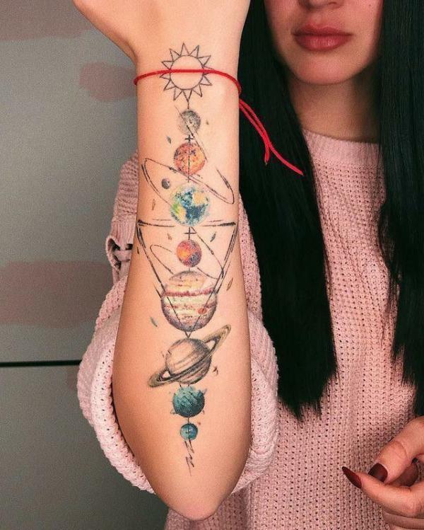 Sun and moon solar system tattoo on outer forearm
