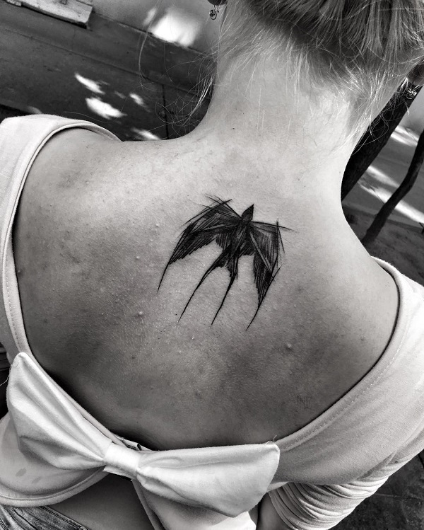 A black Swallow sketchy tattoo on the back of the neck