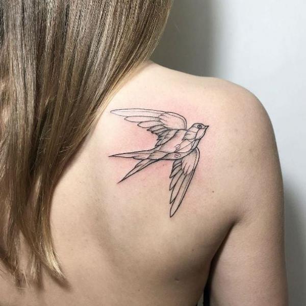 Swallow outline tattoo on shoulder blade