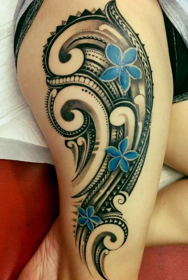 Black and white tribal pattern and blue plumeria thigh tattoo for women