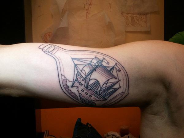 Ship In A Bottle bicep tattoo black and grey