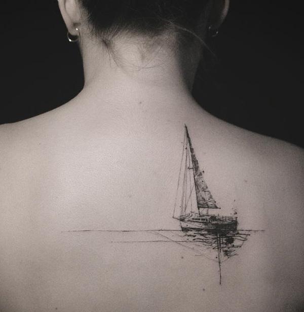 Small sailboat tattoo on shoulder blade