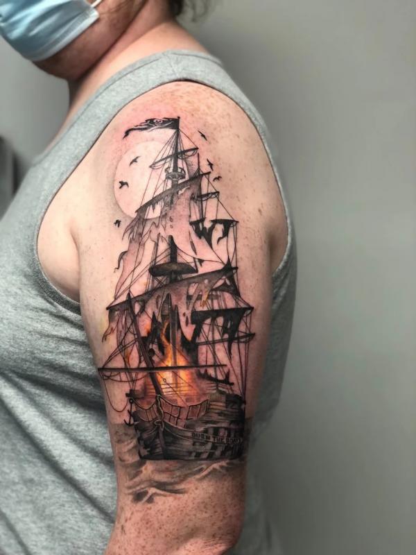 Burning pirate ship sleeve tattoo