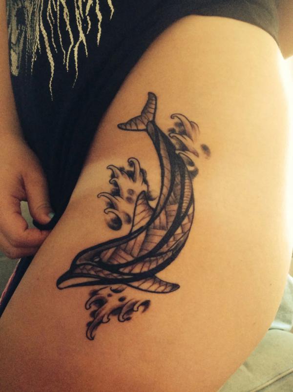 Black and white dolphin in wave tattoo on the side of hip