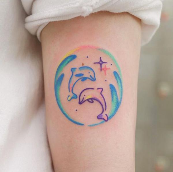 Colorful two dolphin in circle with stars tattoo
