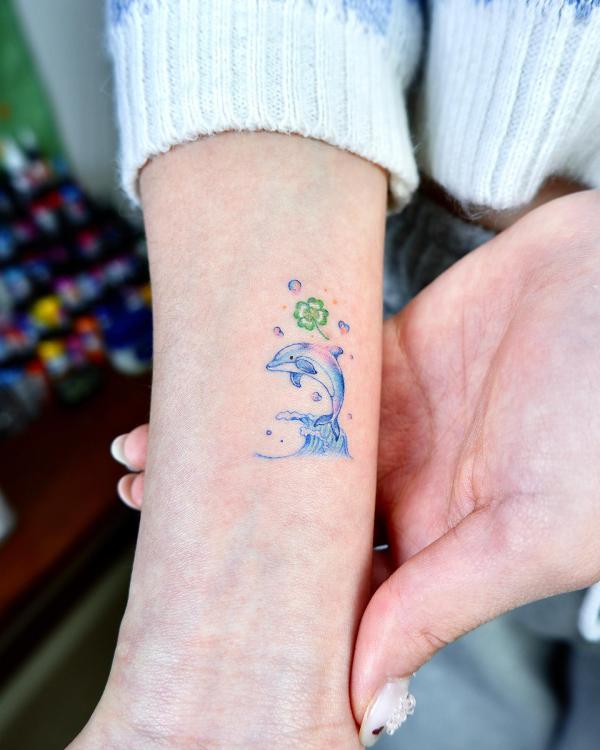 Cute dolphin and shamrock tattoo